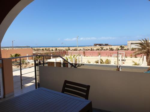 a balcony with a table and a view of the ocean at Aparthotel Por do Sol in Sal Rei