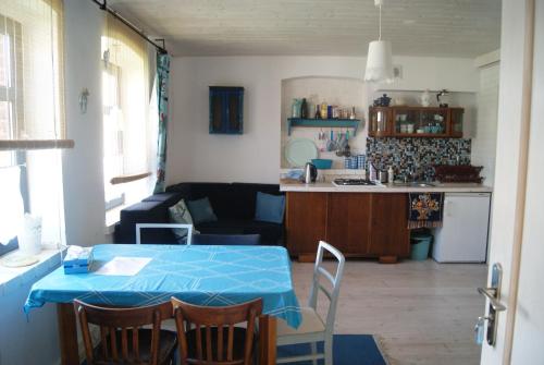 eine Küche und ein Wohnzimmer mit einem blauen Tisch und Stühlen in der Unterkunft Białka B in Białogóra