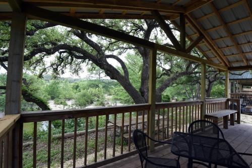 a screened porch with a table and chairs and a tree at River Bluff Cabins in Rio Frio
