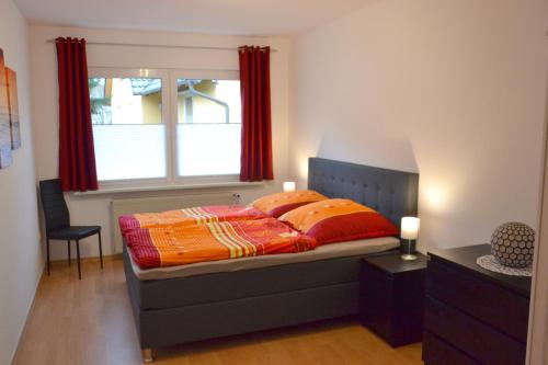 um quarto com uma cama com cortinas vermelhas e uma janela em Ferienhaus Leonie em Barth
