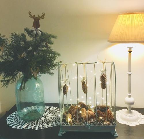 a table with a vase with pine cones and a lamp at Wisełka PERŁA Bałtyku in Wisełka