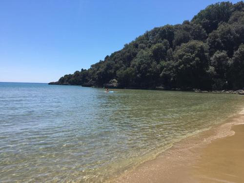 a body of water with a beach and trees at Grand Hotel Il Ninfeo in Gaeta