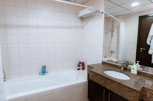 La salle de bains est pourvue d'une baignoire et d'un lavabo. dans l'établissement Bay Central, à Dubaï