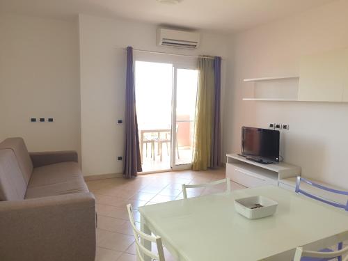 a living room with a table and a couch and a television at Aparthotel Por do Sol in Sal Rei