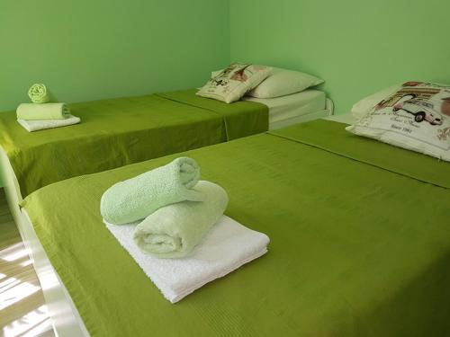a room with two green beds with towels on them at Villa 4 Princesses in Vela Luka