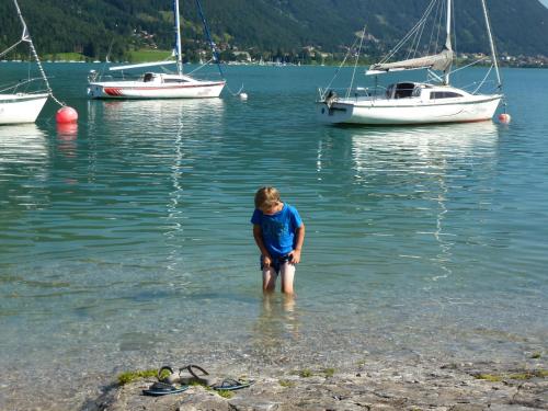 a woman standing in the water with boats in the water at Ferienhof Nogler in Zellberg