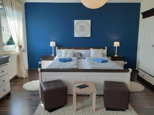 a bedroom with blue walls and a bed with two chairs at Sonnenoase in Deutschkreutz