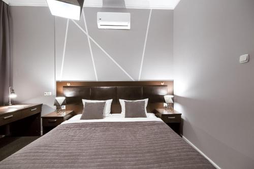 a bedroom with a large bed with two night stands at Park Hotel Bydgoszcz in Bydgoszcz