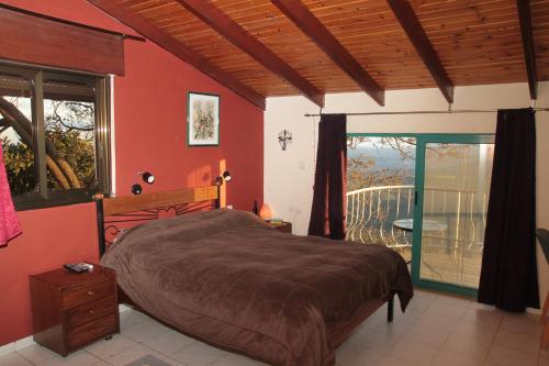 a bedroom with a large bed and a balcony at Switzerland In Amirim in Amirim