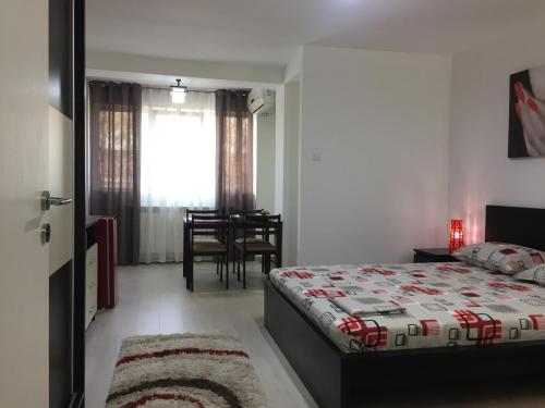 a bedroom with a bed and a dining room at Faleza Apartment in Galaţi