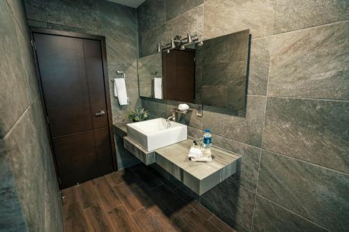 La salle de bains est pourvue d'un lavabo et d'un miroir. dans l'établissement Hotel Corral Grande, à Jamay