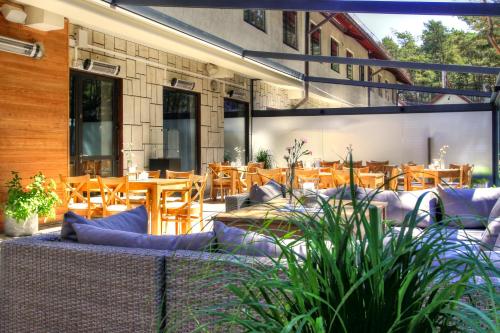 a patio with couches and tables and wooden chairs at Columbus Rowy in Rowy