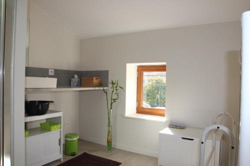 Cette chambre blanche dispose d'une étagère et d'une fenêtre. dans l'établissement Grand duplex au calme en centre-ville, à Villefranche-sur-Saône