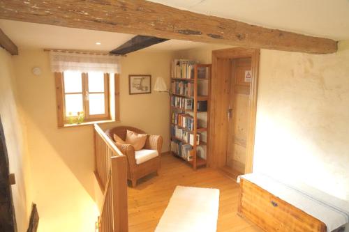 een woonkamer met een stoel en een boekenplank bij Ferienhaus am Solling in Dassel