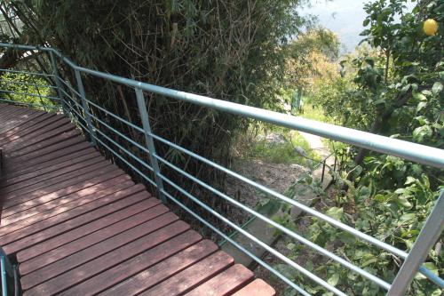a wooden walkway with a metal railing on a hill at Switzerland In Amirim in Amirim