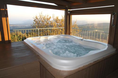 a jacuzzi tub sitting on top of a balcony at Switzerland In Amirim in Amirim