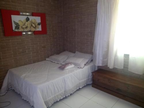 un piccolo letto in una camera con muro di mattoni di Meu lugar sana a Sana