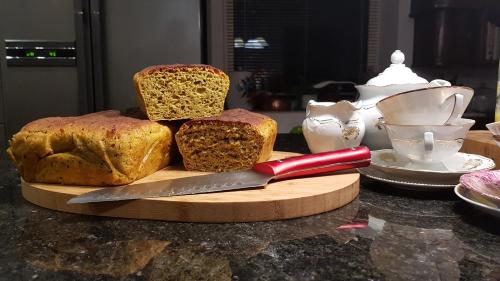 a cutting board with three slices of bread and a knife at Dom Gościnny Hansel & Gretel in Kallinowen