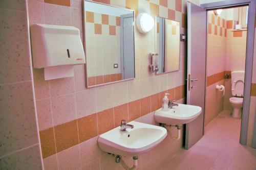 a bathroom with two sinks and a toilet at Ostello La Miniera in Massa Marittima