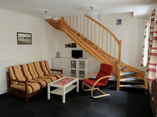 a living room with a couch and a staircase at Apartman U Hippolyta in Jindřichŭv Hradec