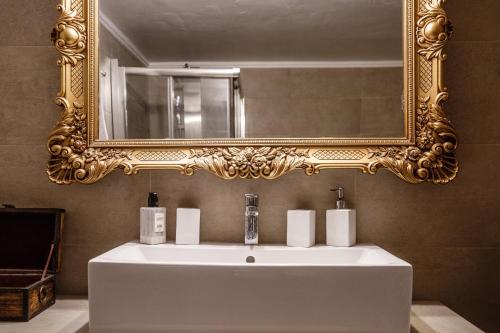 uma casa de banho com um lavatório branco e um espelho. em The Orange Garden em Nafplio