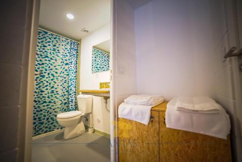 a small bathroom with a toilet and a shower at Antas Guest House in Esposende