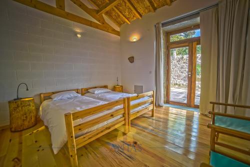 a bedroom with two beds and a large window at Antas Guest House in Esposende