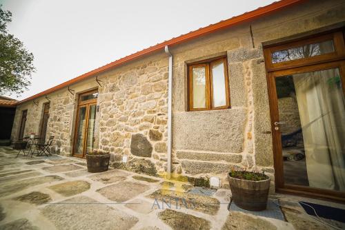 a stone building with windows and a patio at Antas Guest House in Esposende