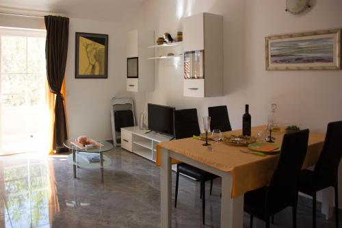 a living room with a dining room table with chairs and a television at BMB Apartments in Senj
