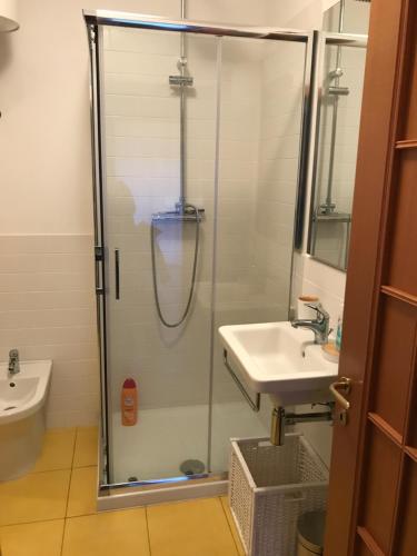 y baño con ducha y lavamanos. en La Lampara Apartment en Aci Castello