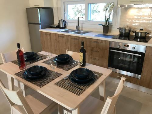 a kitchen with a table with plates and wine glasses at Sirios in Acharavi