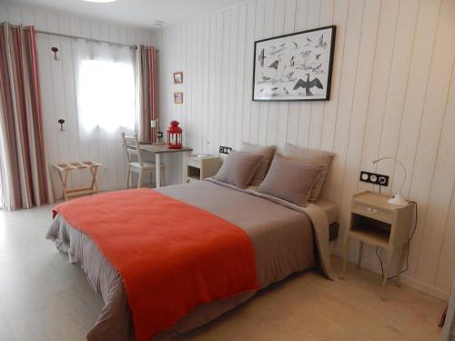 a bedroom with a bed and a table and a window at Balade Océane in Loctudy