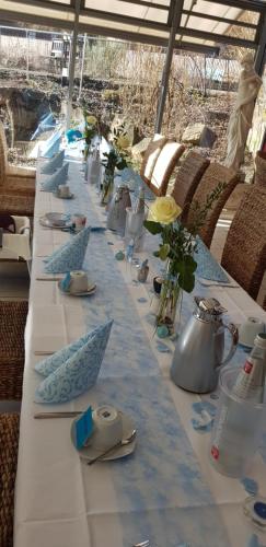 a long table with blue and white table cloth at Hotel & Café Schachtenburg in Schlitz