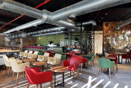 a restaurant with red and green chairs and tables at Family Selection at Grand Palladium Costa Mujeres Resort & Spa - All Inclusive in Cancún