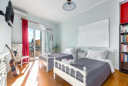 a bedroom with two beds and a book shelf at Garitsa Maisonette in Corfu Town