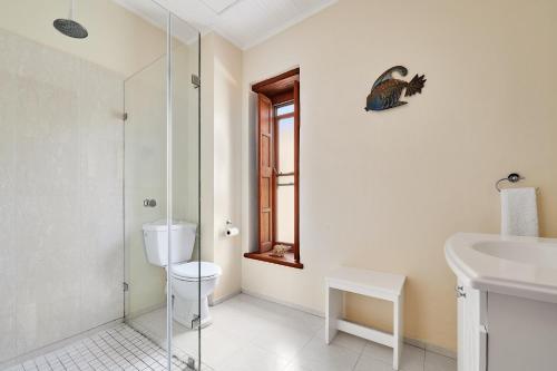 Un baño con inodoro, lavabo y ducha. en Greystones Beach House, en Langebaan