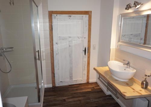 a bathroom with a white sink and a shower at Ferienhaus Hundertmorgenfeld 33 in Wernigerode