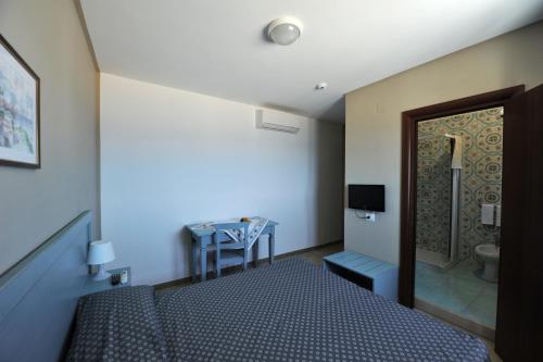 a bedroom with a bed and a bathroom with a toilet at Lido Impero in Palagiano