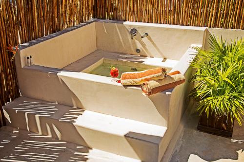 a bath tub with a sink next to a fence at Maria Del Mar Tulum - Adults Only in Tulum