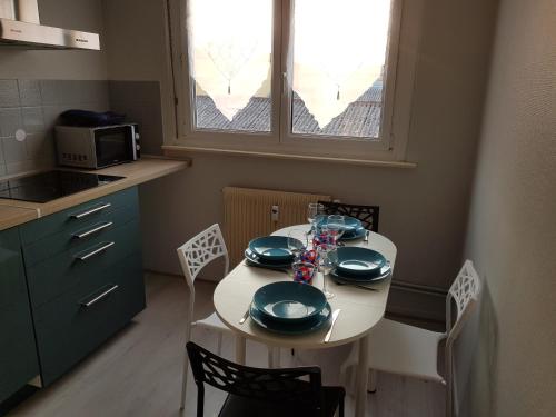 - une cuisine avec une table et de la vaisselle dans l'établissement Le Bellevue, à Colmar
