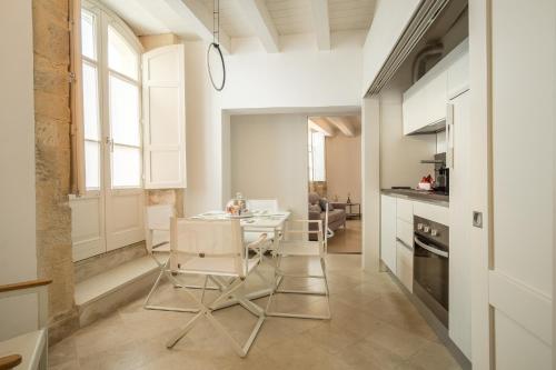 a kitchen with a table and chairs in a room at Palazzo Alfeo Aparthotel in Siracusa