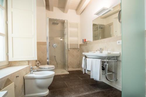 a bathroom with a toilet and a sink and a shower at Palazzo Alfeo Aparthotel in Siracusa