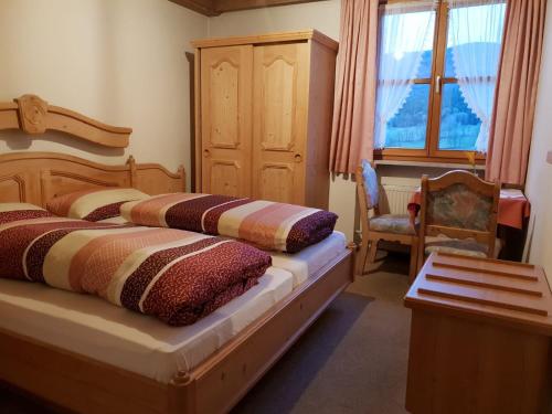 a bedroom with two beds and a chair and a window at Pension / Ferienwohnungen Ludwig in Rimbach