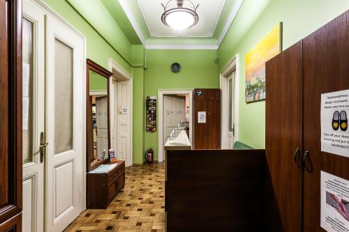 a hallway with green walls and wooden floors at Leosphere Hostel in Lviv