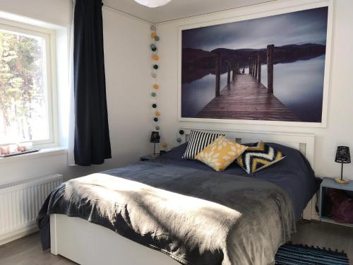 ein Schlafzimmer mit einem Bett mit einem Bild eines Piers in der Unterkunft SINITALO in Inari