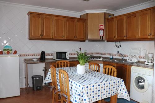 a kitchen with a table with a tablecloth on it at Cantinho da Cacilda in Grândola