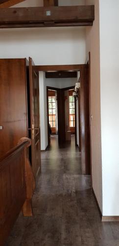 an empty hallway with wooden floors and doors at Rue de Bel-Aube Chalet Joli 10 in Crans-Montana