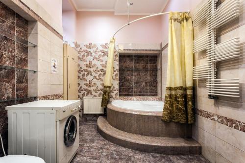 a bathroom with a tub and a shower with a washing machine at Leosphere Hostel in Lviv
