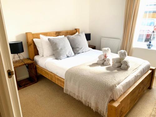 two teddy bears are sitting on a bed at Home Crowd Luxury Apartments in Doncaster