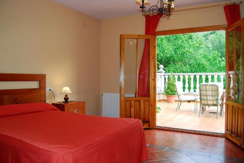 a bedroom with a bed and a sliding glass door at La Noguera in Palomera